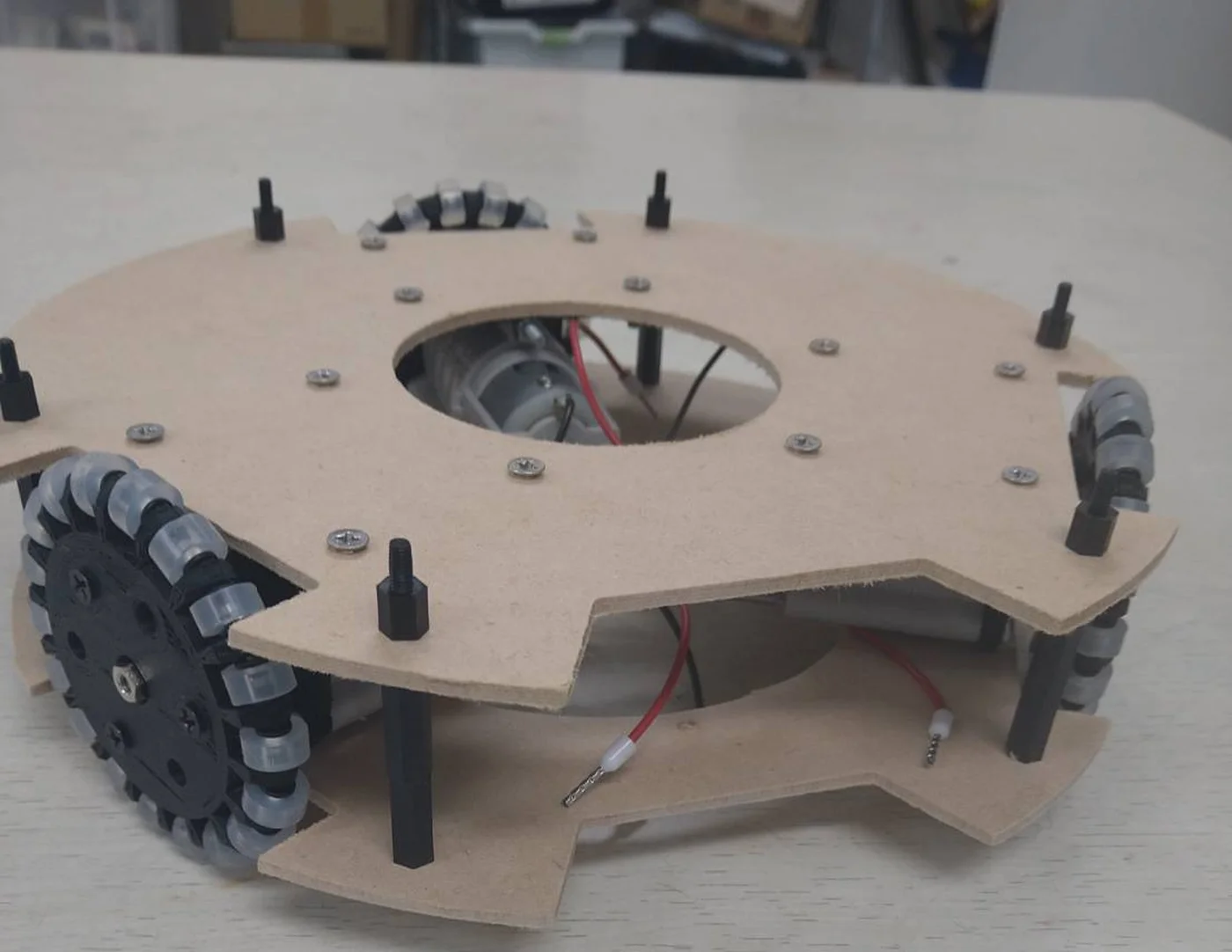 木の板を2枚重ねて作ったロボットの土台。オムニホイールとモーターが取り付けられている