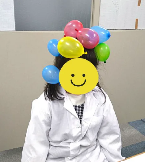 頭にミニ風船がたくさんくっついている様子